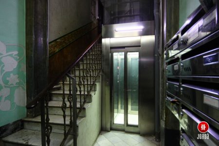 Frontal de ascensor con chapa inoxidable instalado en edificio de comunidad de propietarios