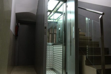 Puerta ascensor semiautomática abierta instalado en una comunidad de propietarios