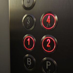 Pulsadores iluminados en rojo de una columna de botonera en cabina de ascensor
