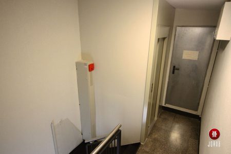 Cuadro de maniobra de un ascensor al lado del cerramiento en la escalera