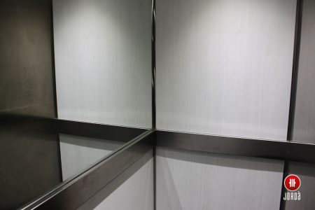 Interior de una cabina de ascensor con medio espejo